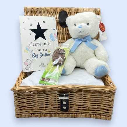 Sibling Gift, White & Blue Teddy Bear, with a countdown to becoming a big brother plaque and a milk chocolate dinosaur lolly in a 12" wicker basket