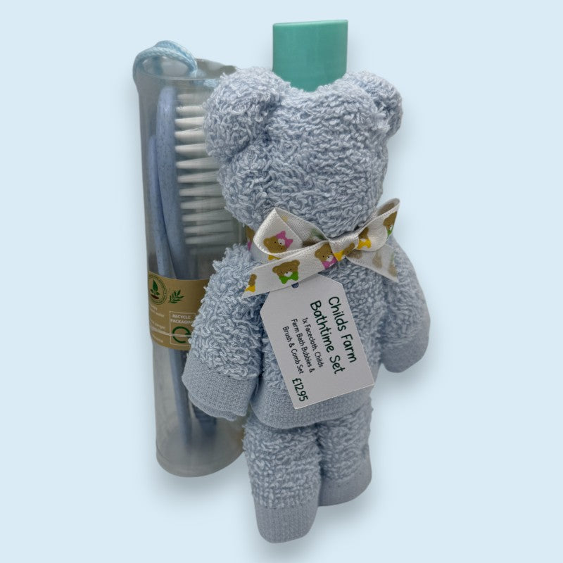 Blue face cloth teddy bear with a bow tie, comb, and brush set on a pale blue background