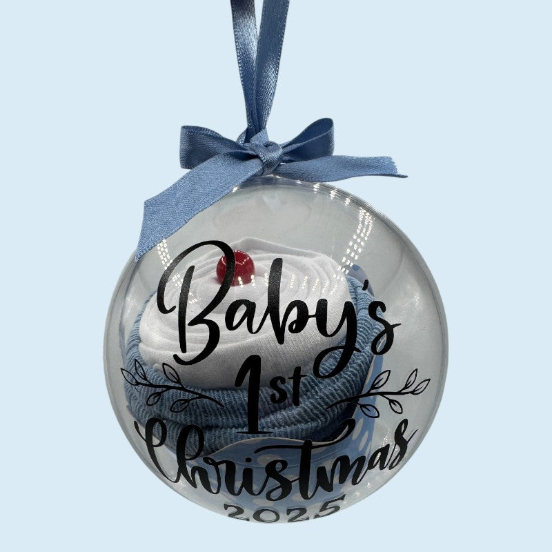 Decorative Christmas ornament with baby's first Christmas text and blue ribbon on a light blue background