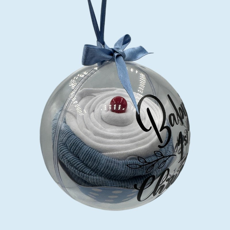 Decorative fillable "cupcake" bauble with baby clothes and 'Baby's 1st Christmas 2025' text on a light blue background