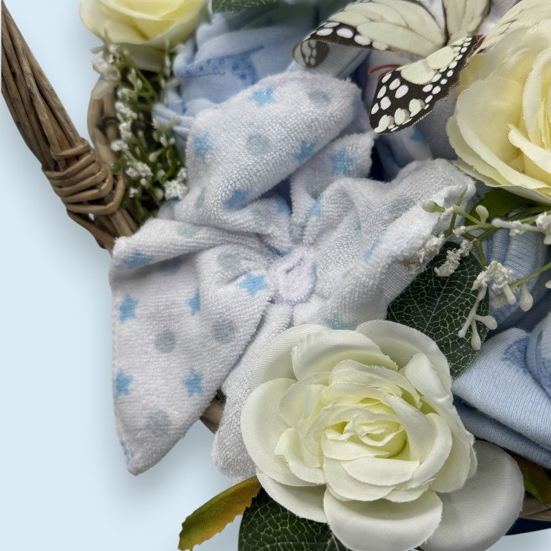 9-piece layette set and towel arranged in floral wicker basket