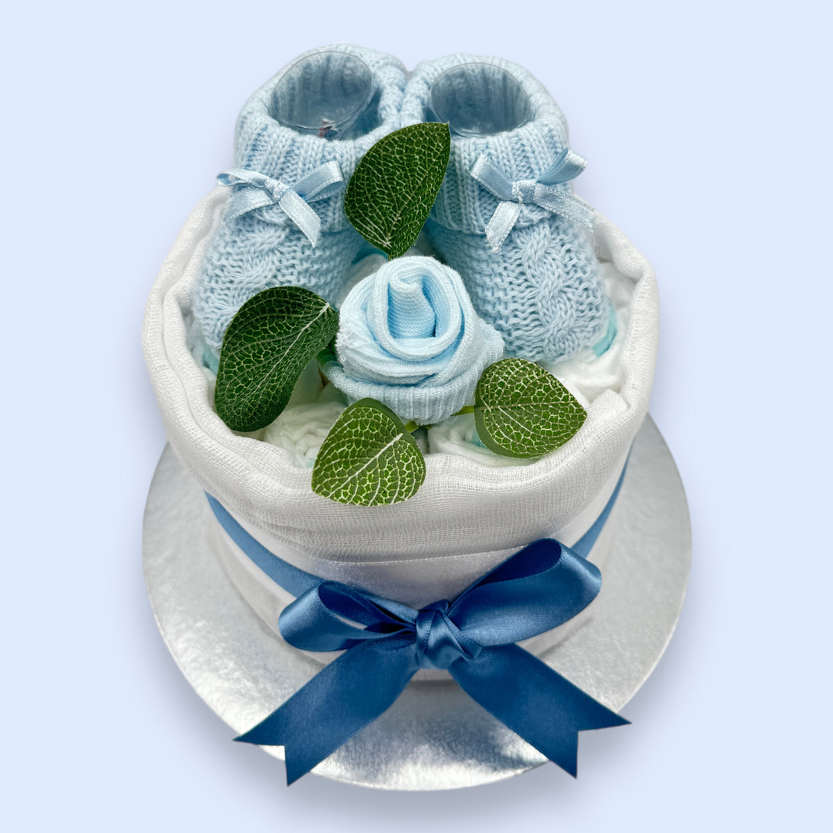 Baby boy nappy cake with blue knitted booties, sock rose, muslin and satin ribbon