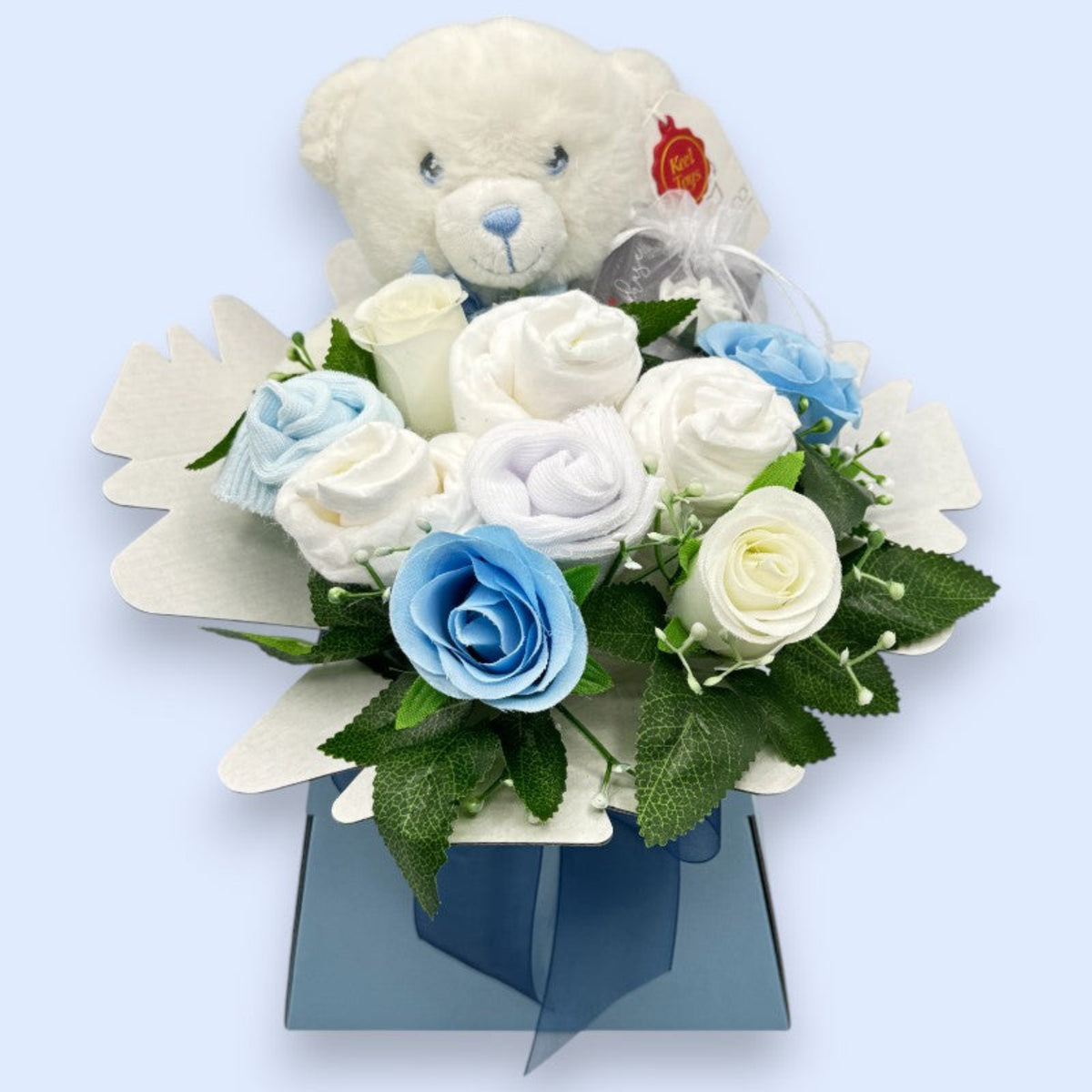 Front view of blue Baby Blossom gift box with teddy bear, Pampers nappies, baby socks and roses