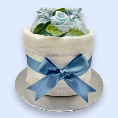 Blue baby nappy cake showing Pampers nappies, knitted booties and baby sock rose