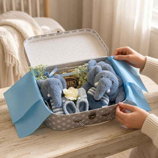 Blue new baby gift suitcase with soft toys, booties and chocolates being revealed