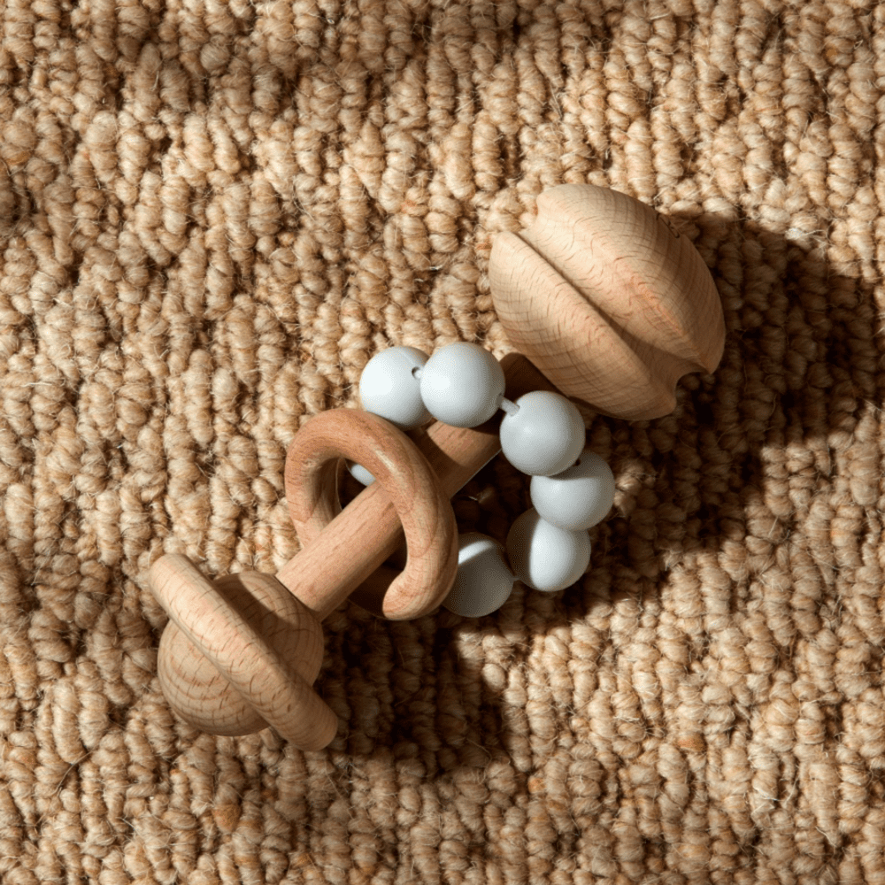 Grey silicone and wood teether styled as a gender-neutral baby gift