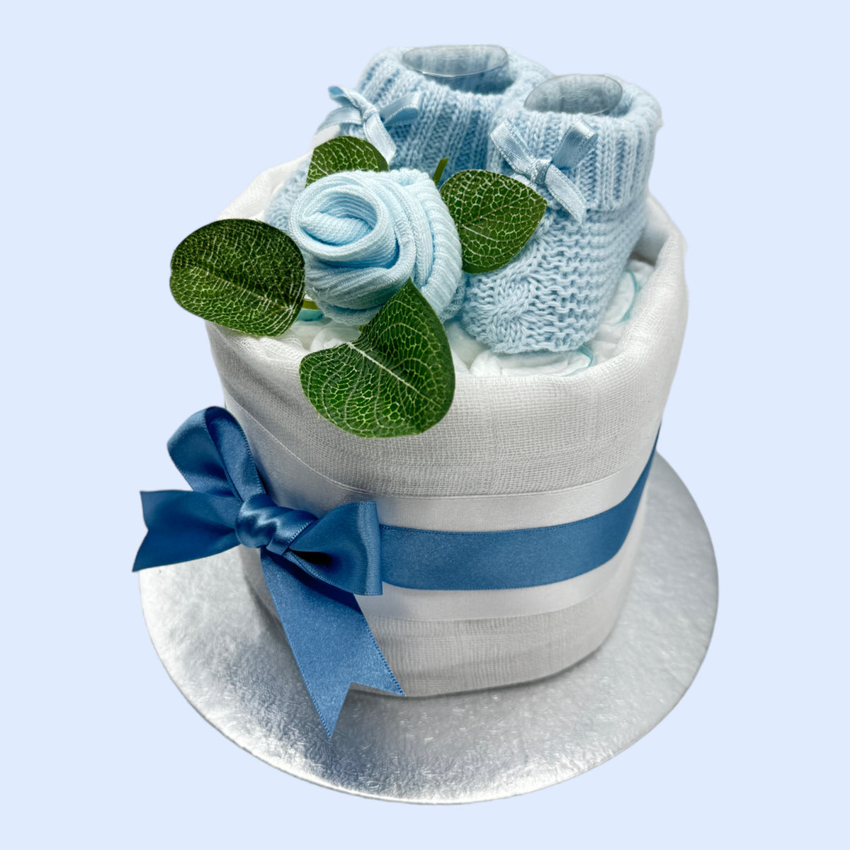 Handmade blue nappy cake with white muslin, baby booties and satin bow