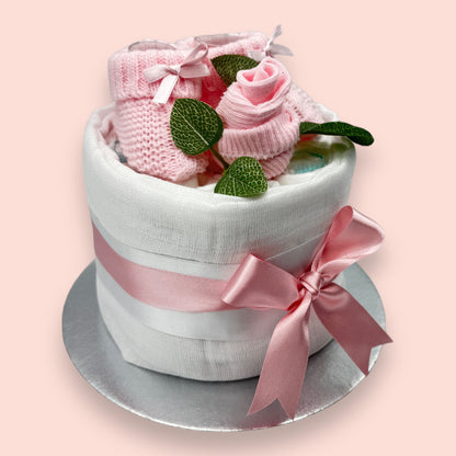 Handmade pink nappy cake with white muslin, baby booties and satin bow
