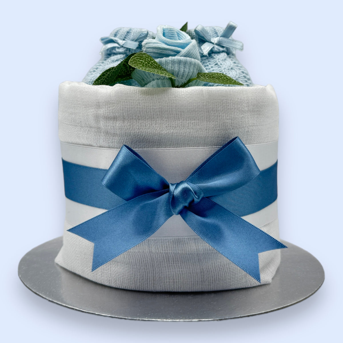 Mini blue nappy cake with knitted baby booties, sock rose and blue satin bow