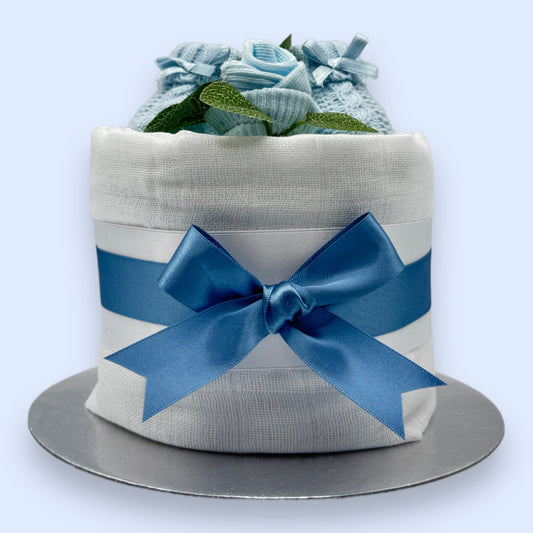 Mini blue nappy cake with knitted baby booties, sock rose and blue satin bow