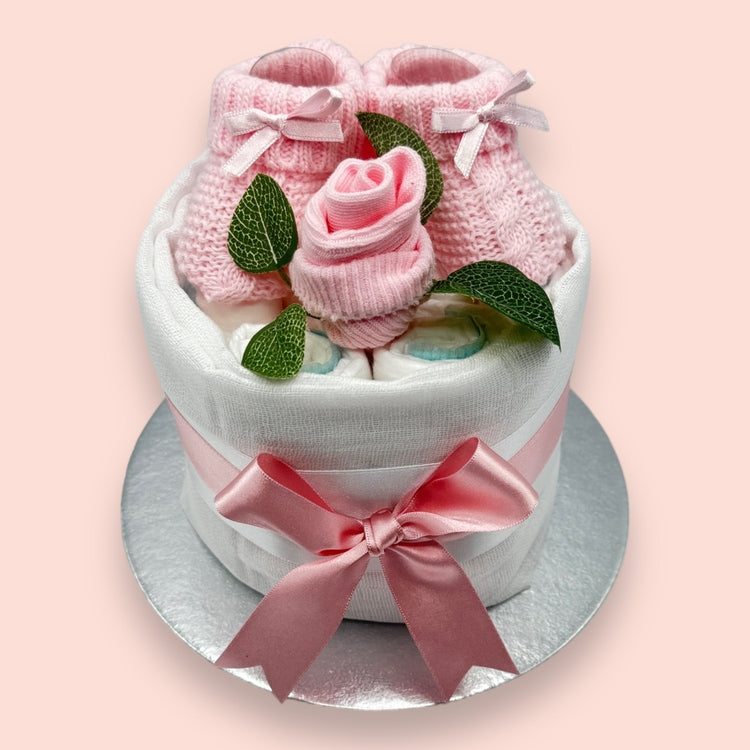 Hand-styled pink mini nappy cake for newborns with socks and booties