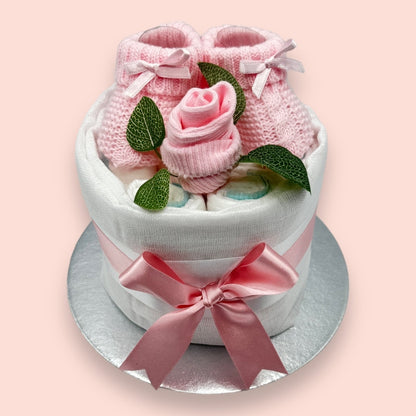 Hand-styled pink mini nappy cake for newborns with socks and booties