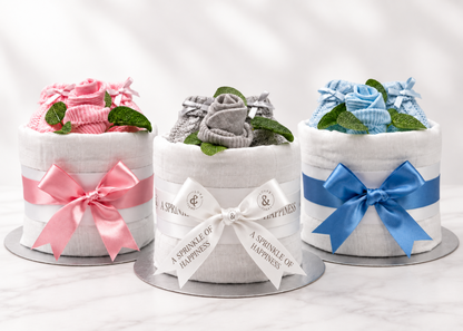 Mini nappy cake collection in pink, neutral and blue with knitted baby booties