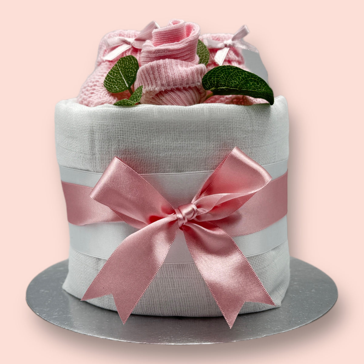 Mini pink nappy cake with knitted baby booties, sock rose and pink satin bow