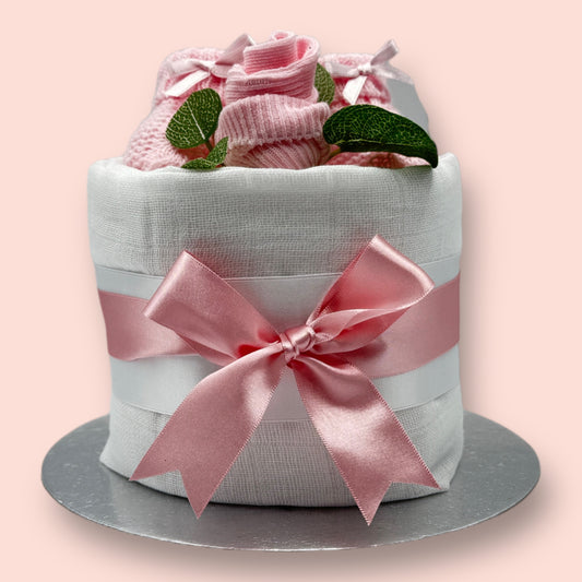 Mini pink nappy cake with knitted baby booties, sock rose and pink satin bow