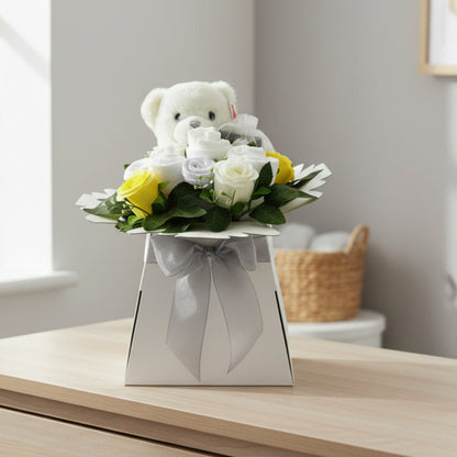 Neutral Baby Blossom gift box styled in a nursery with teddy bear, baby essentials and yellow and white roses
