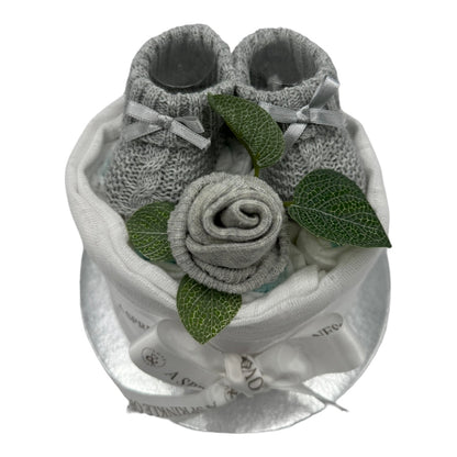 Top view of neutral nappy cake showing Pampers nappies, knitted booties and baby sock rose