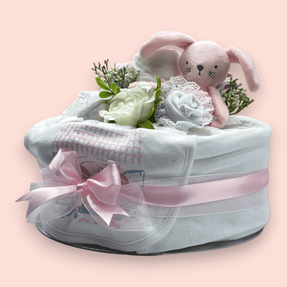 Left Side View - Elegant pink nappy cake with baby clothing arrangement and soft toy